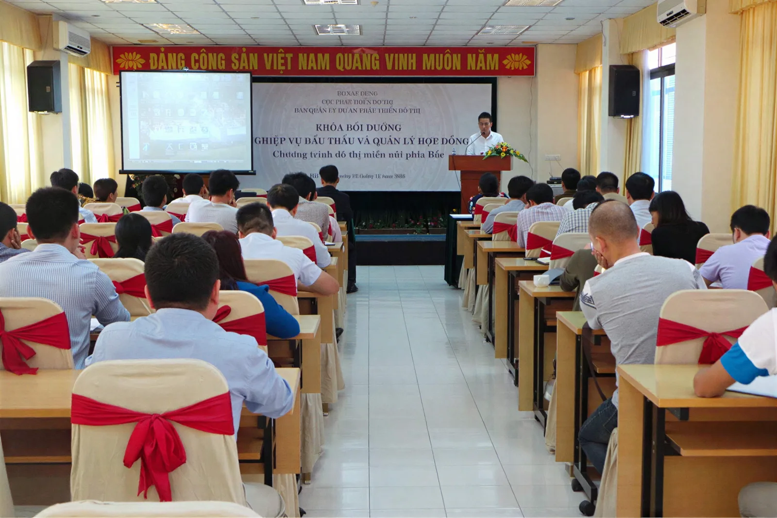 Hội trường khóa đào tạo nghiệp vụ đấu thầu và quản lý hợp đồng Hội trường khóa đào tạo nghiệp vụ đấu thầu và quản lý hợp đồng của Viện với hàng ghế học viên và sân khấu trình bày.