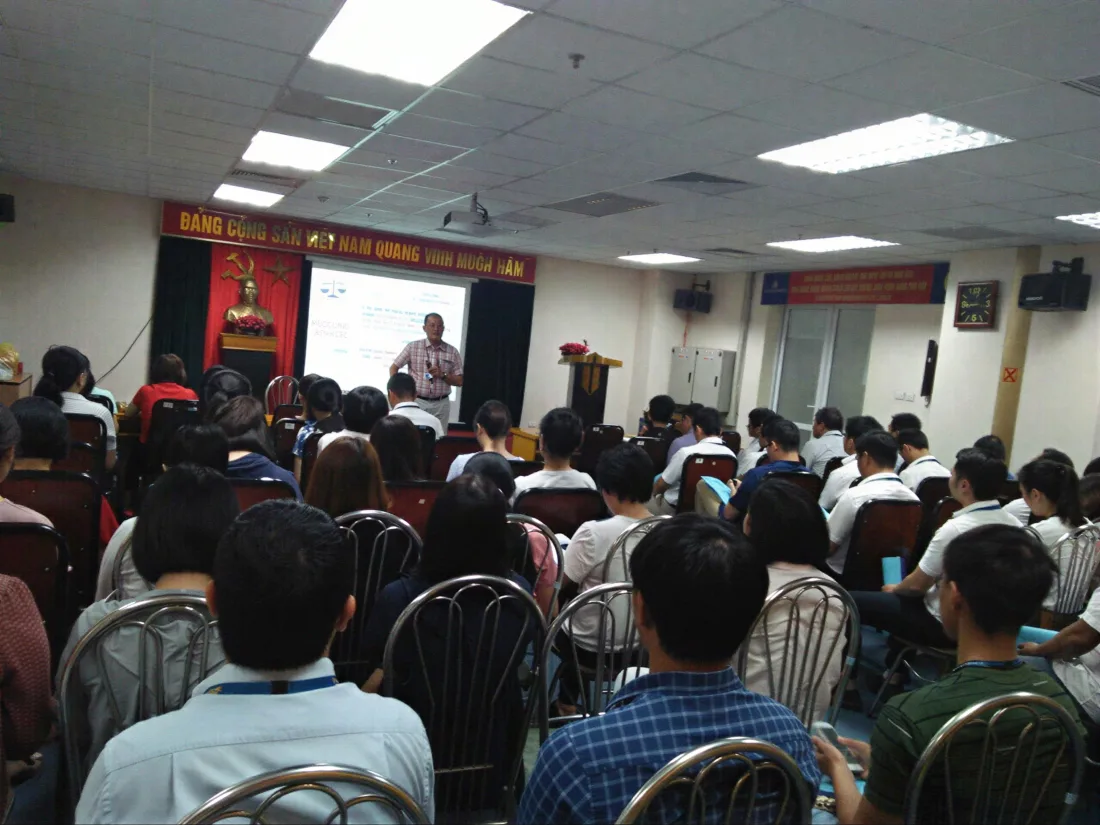 Lớp đào tạo nghiệp vụ đông học viên tham dự, giảng viên đứng lớp phía trước cùng màn hình trình chiếu nội dung.