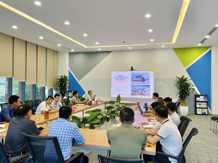 Lớp đào tạo nghiệp vụ tổ chức tại đơn vị trong phòng họp hiện đại, học viên trao đổi quanh bàn cùng màn hình trình chiếu.