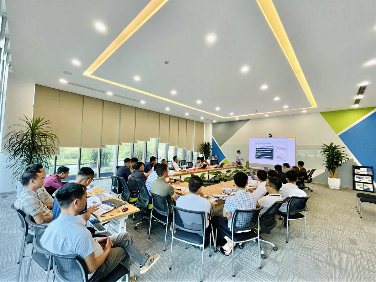 Phòng đào tạo hiện đại của lớp bồi dưỡng nghiệp vụ Lớp bồi dưỡng nghiệp vụ trong phòng đào tạo hiện đại, nhiều ánh sáng, học viên ngồi quanh bàn cùng màn hình trình chiếu.