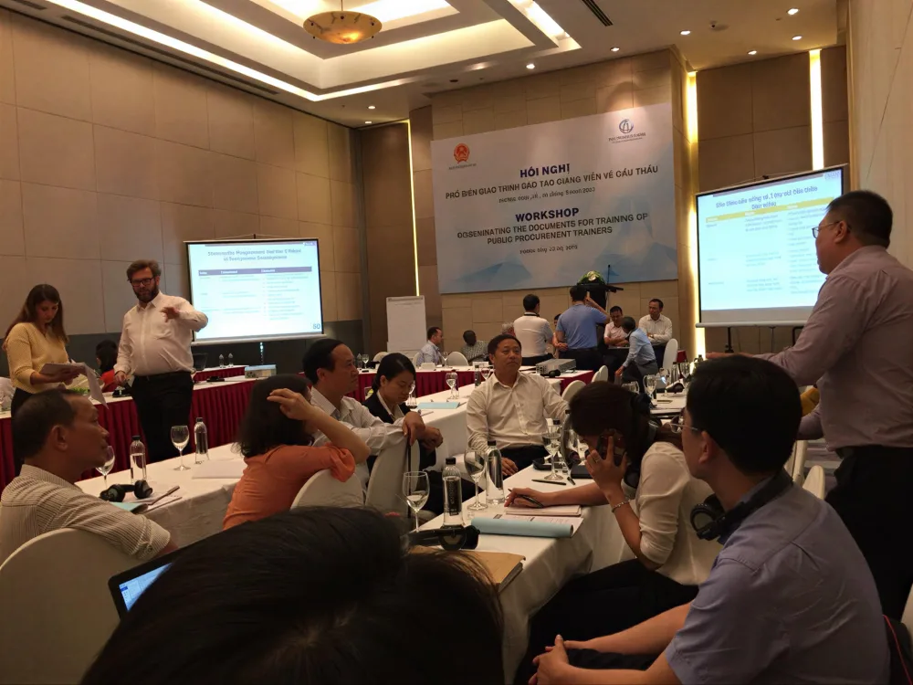 Buổi workshop nghiệp vụ chuyên môn với hai màn hình trình chiếu và các nhóm học viên trao đổi tại bàn thảo luận.